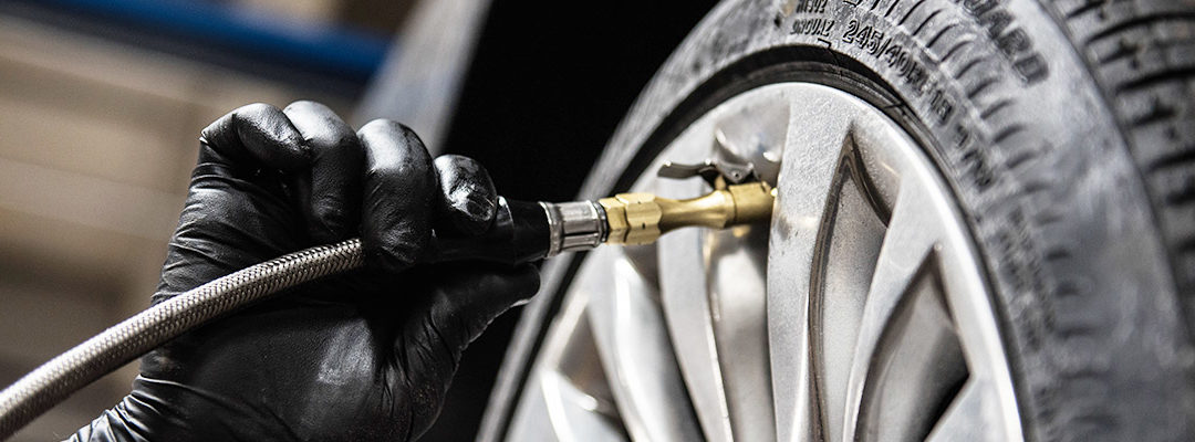 gloved hand filling up tire with air