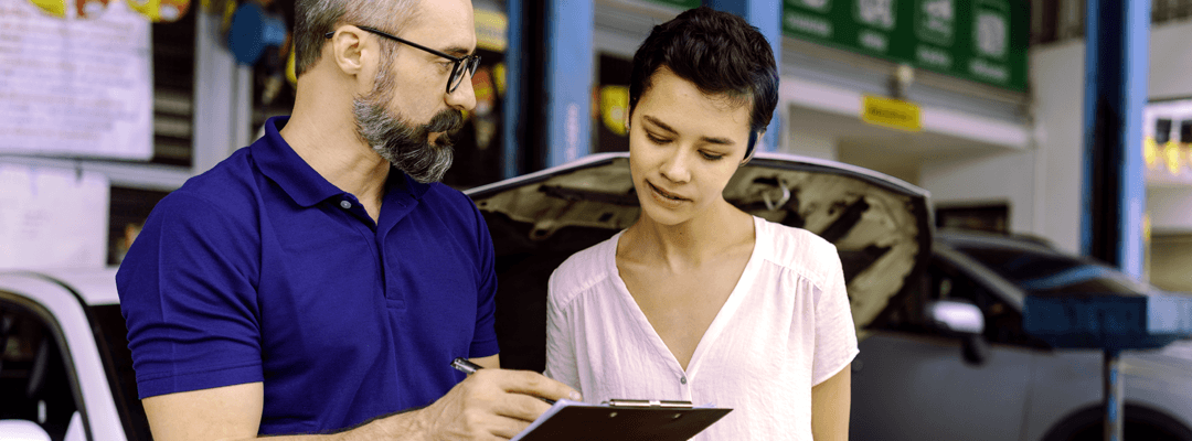 Loyal customer discussing maintenance with service department member.