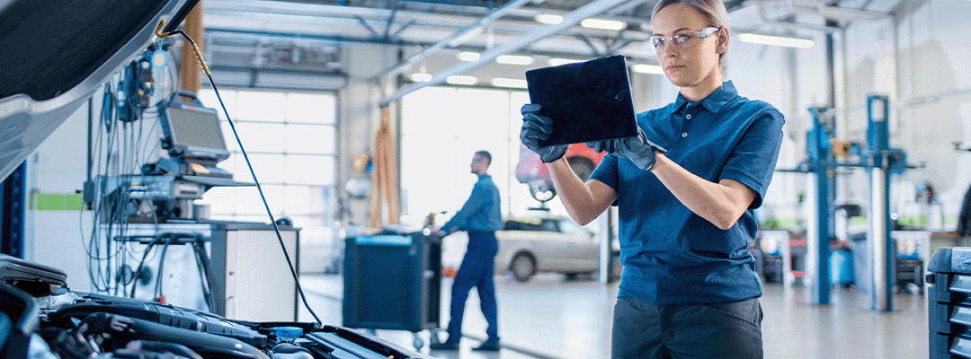 female mechanic looking at customer information on tablet