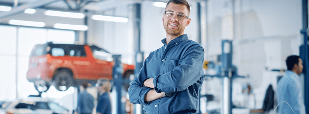 auto mechanic crossing arms smiling